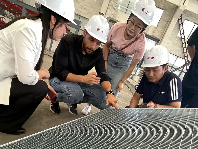 customers inspecting galvanized steel grating panel details in factory